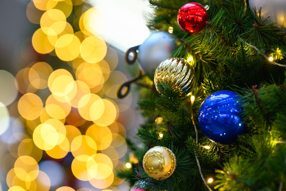 Un primer plano de un árbol de Navidad con luces en el fondo