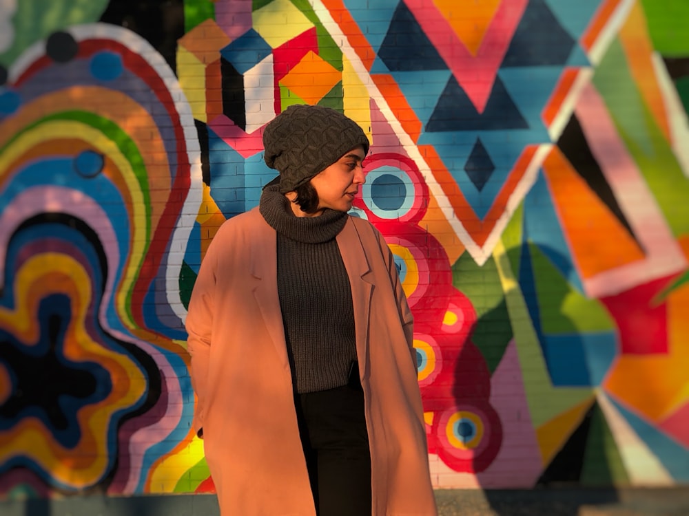 a woman standing in front of a colorful wall