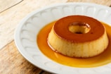 Dessert of creamy flan topped with caramel sauce in a small glass dish.