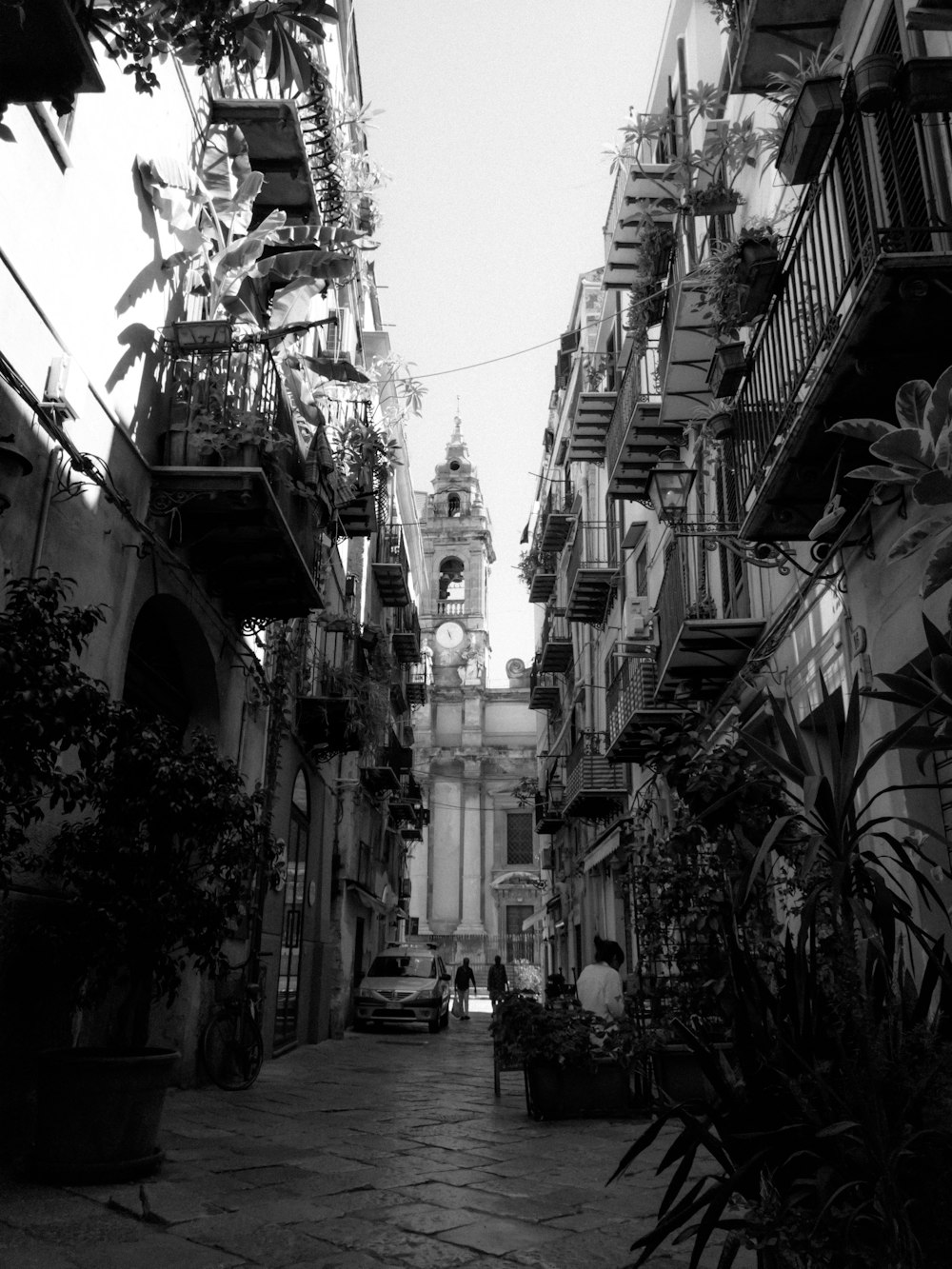 a black and white photo of a narrow city street