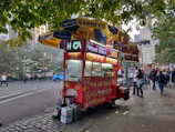 A vibrant street cart with the Uncle Larry Momos logo, bustling with happy customers.