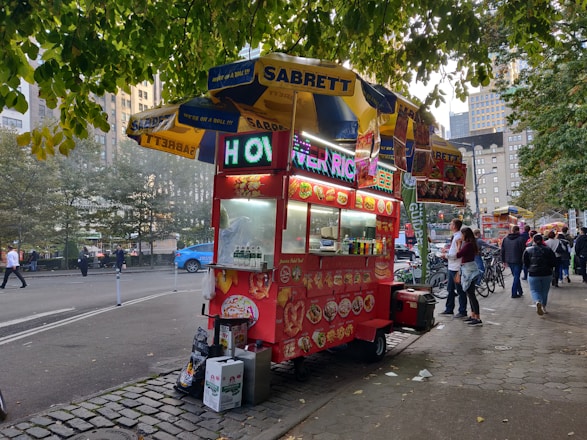 A vibrant street food cart with Mateus Lima serving happy customers.