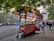 A vibrant food cart serving a variety of dishes at a busy street corner.