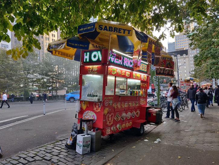 A vibrant food cart with colorful decorations and fresh ingredients displayed.