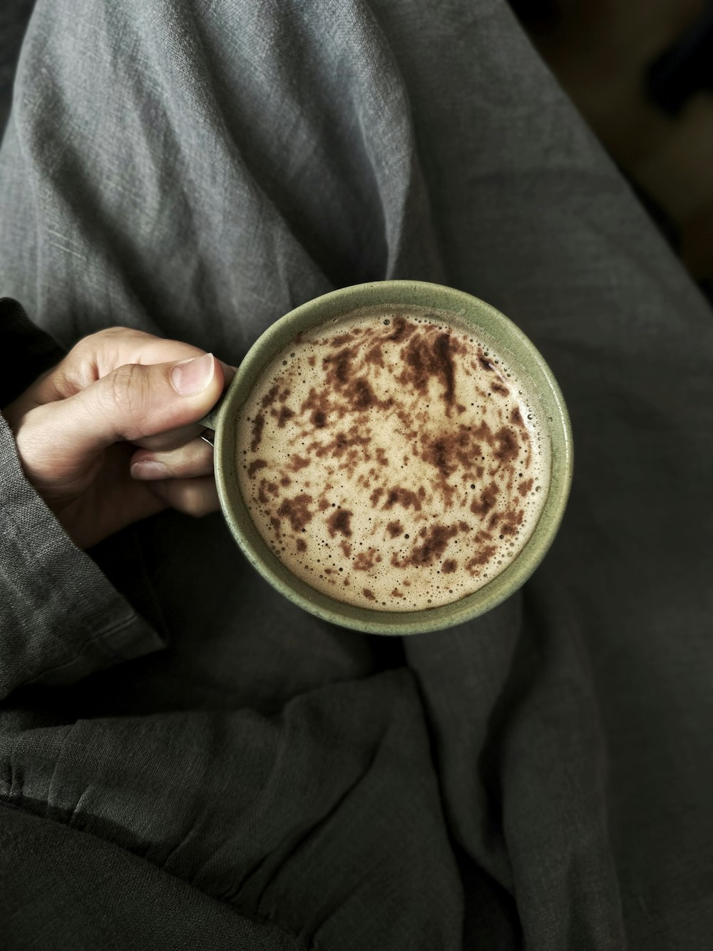 a person holding a cup of hot chocolate