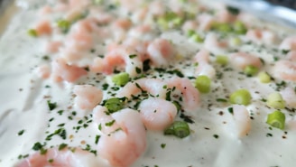 A close-up shot of creamy callaloo with a sprinkle of fresh herbs, showcasing its rich texture.