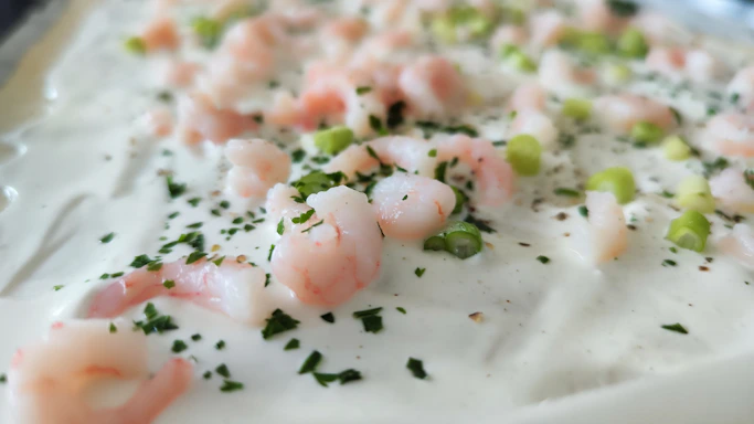 Close-up of a beautifully plated shrimp and grits dish with vibrant colors and elegant presentation.