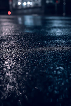 a blurry photo of a wet street at night