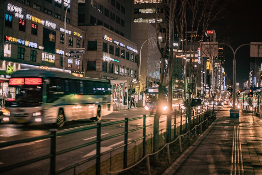 a bus driving down a city street at night