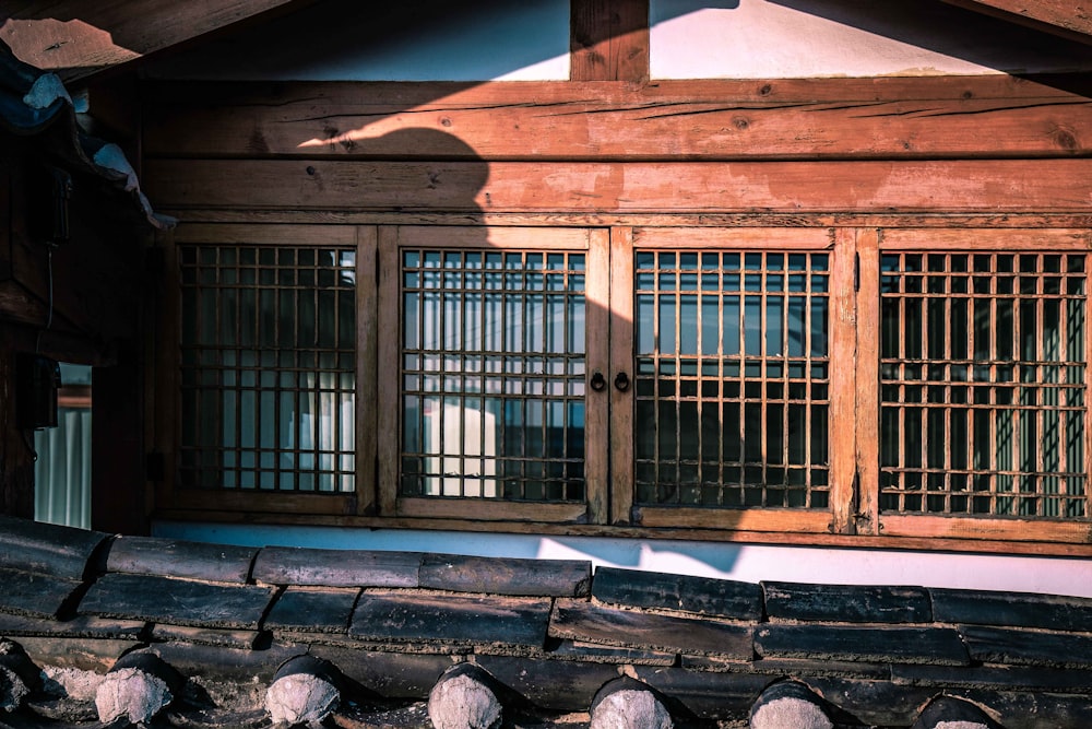 a wooden building with windows and bars on the outside