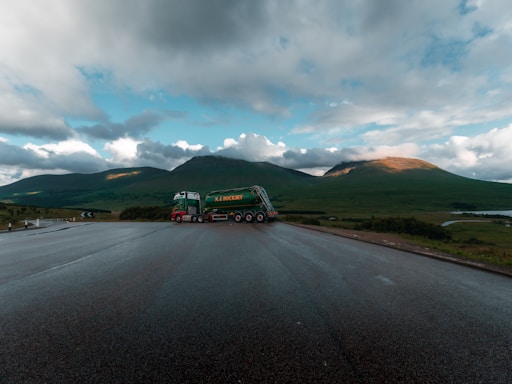 A sturdy semi-truck parked by a roadside under a wide-open sky, ready for a long haul.