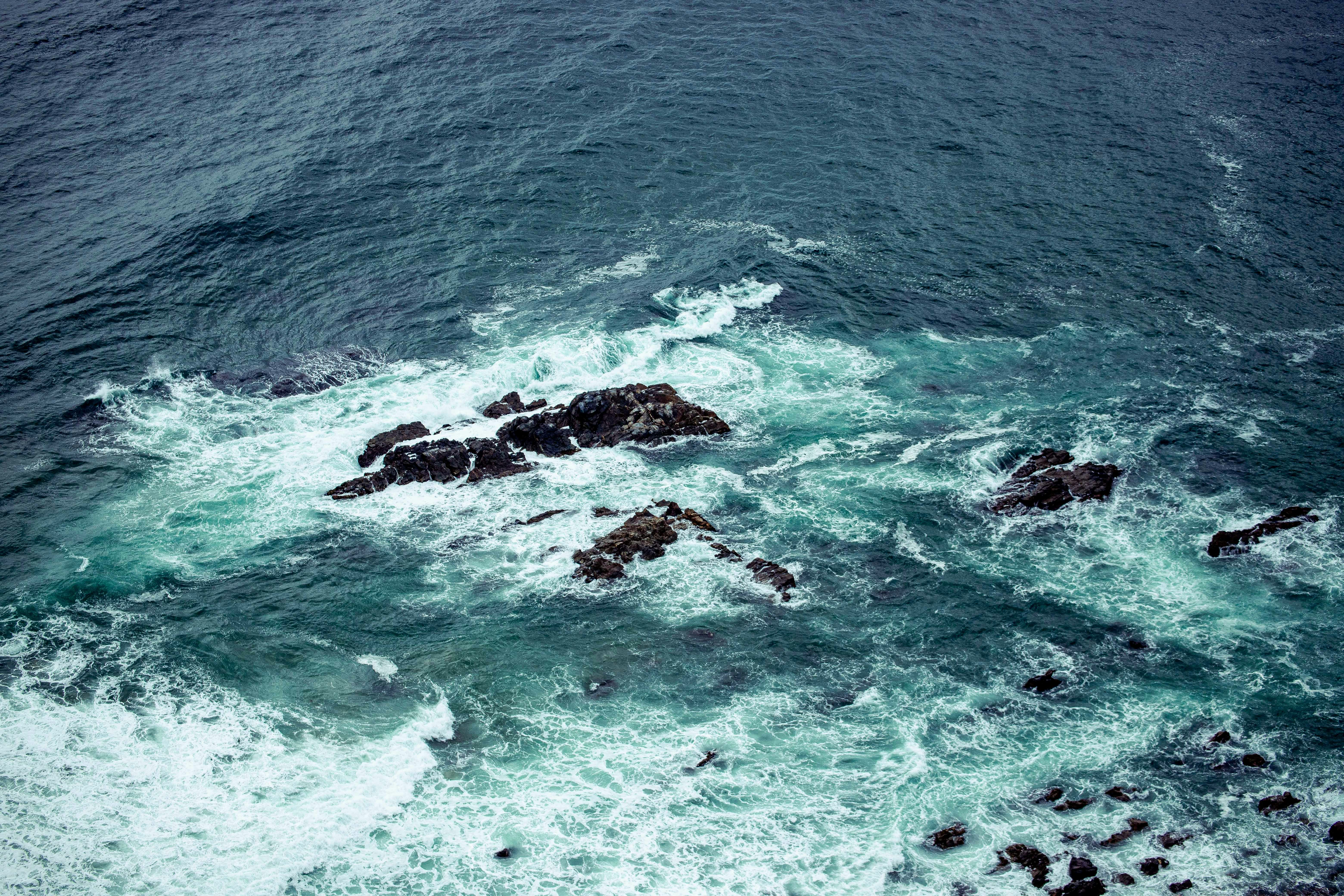 an aerial view of a body of water surrounded by rocks