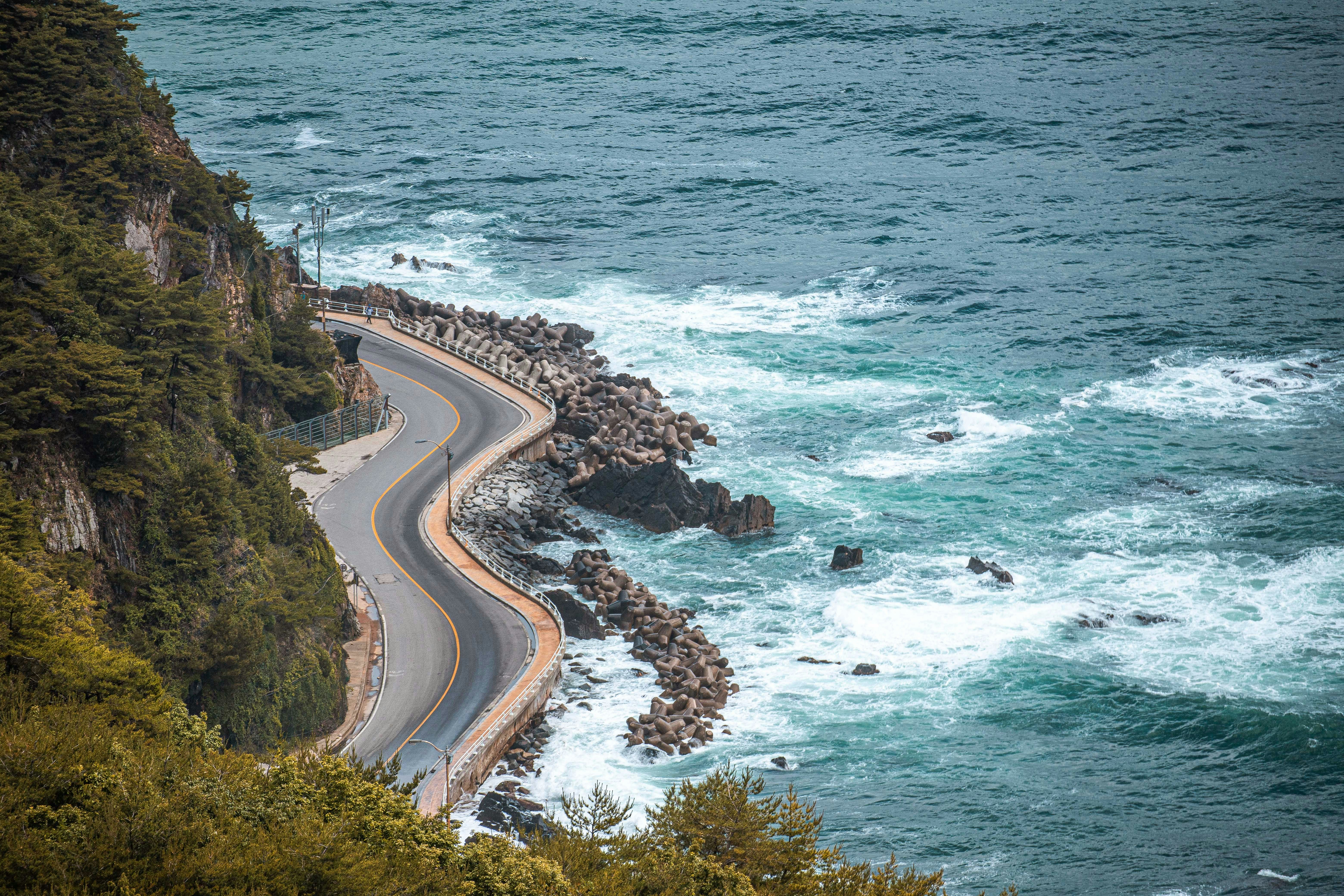 a winding road next to a body of water