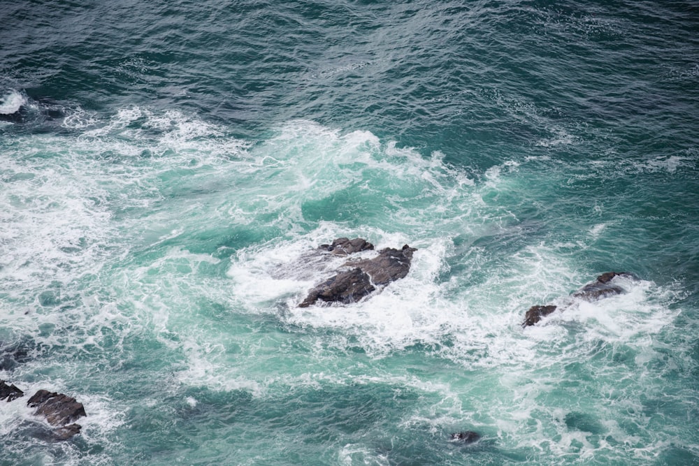 a group of rocks in the middle of a body of water