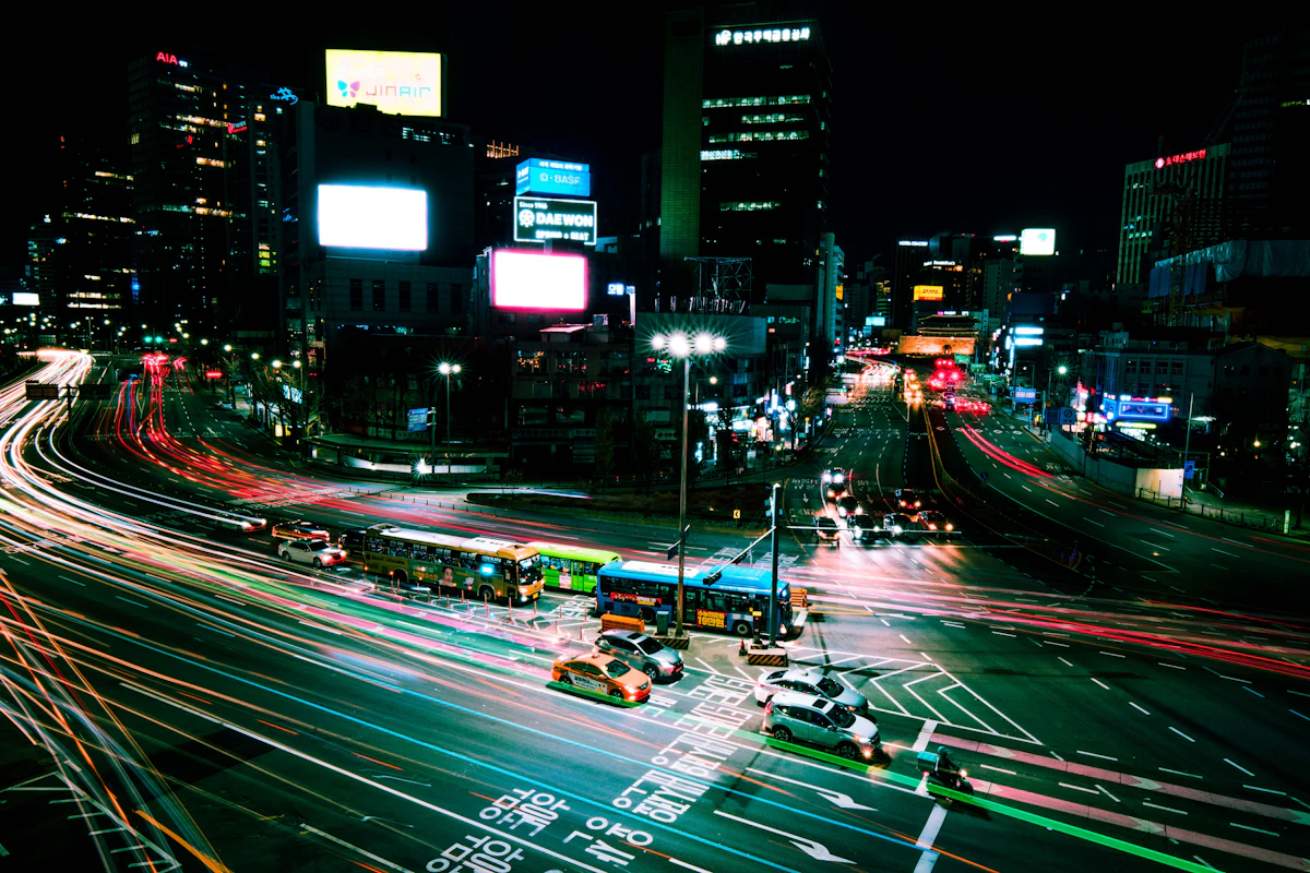 Light trails from buses and cars across a Seoul intersection at night