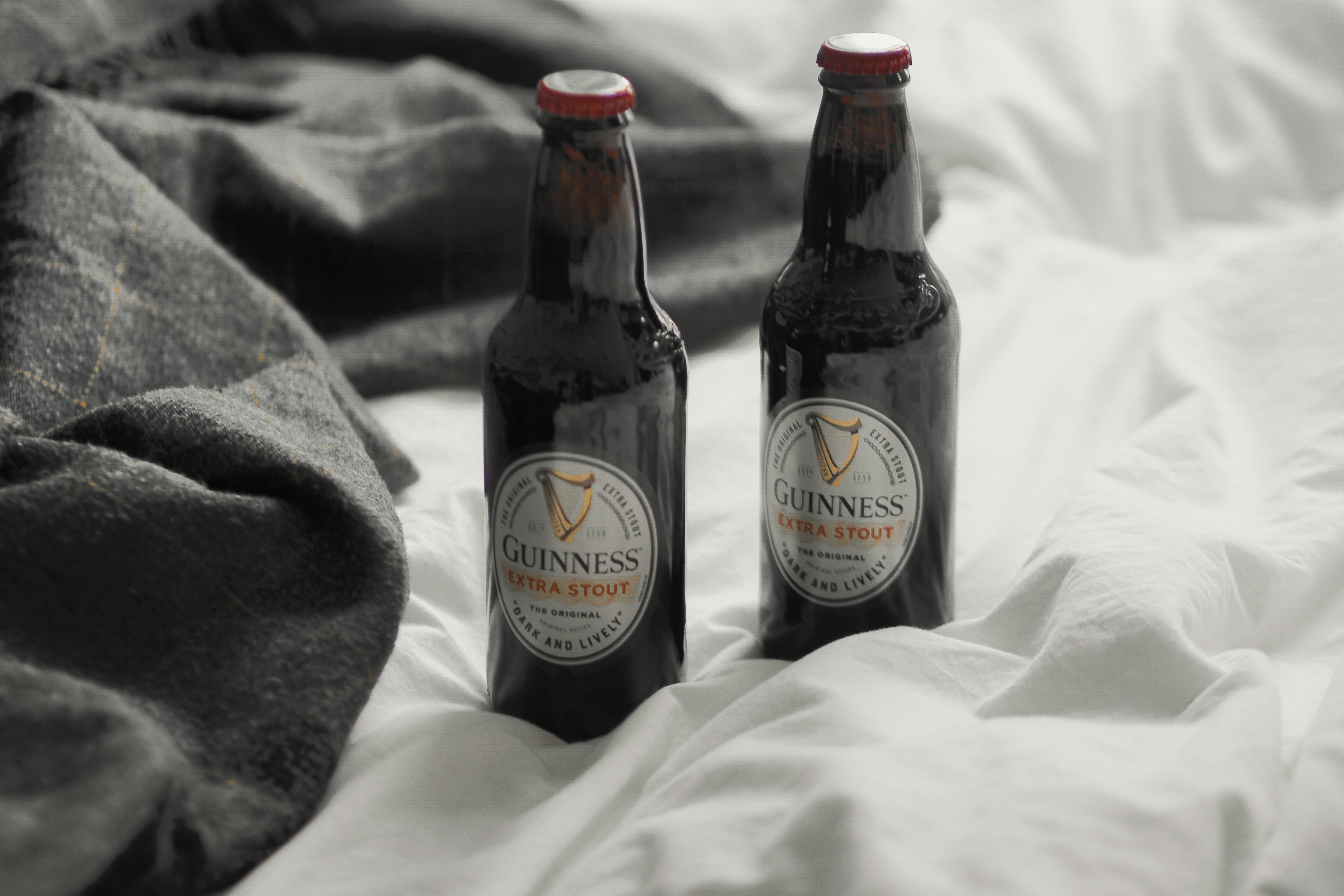 Two bottles of beer sitting on top of a bed photo Free Ireland Image