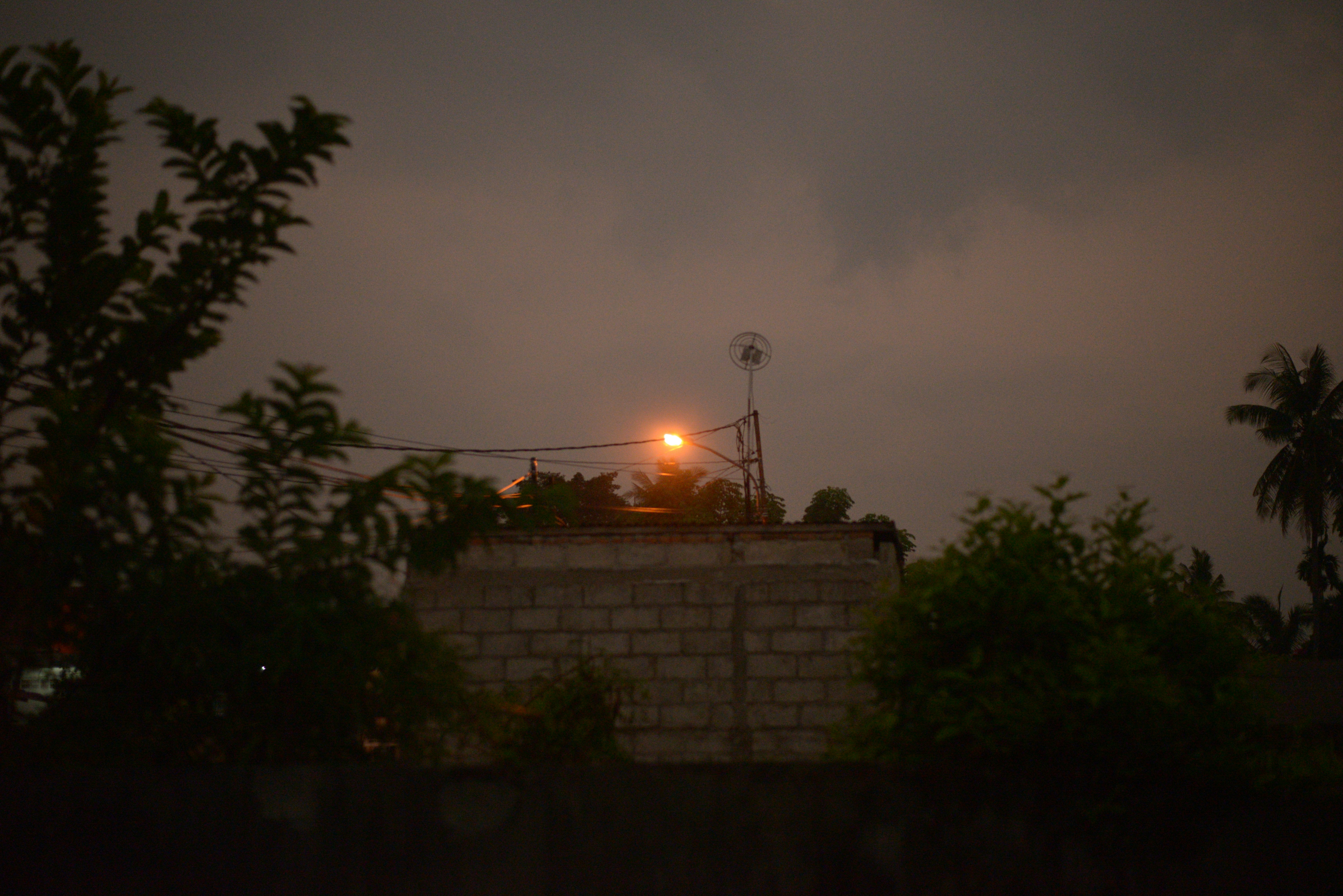 Gritty urban brick wall with warm street lamp glow at dusk