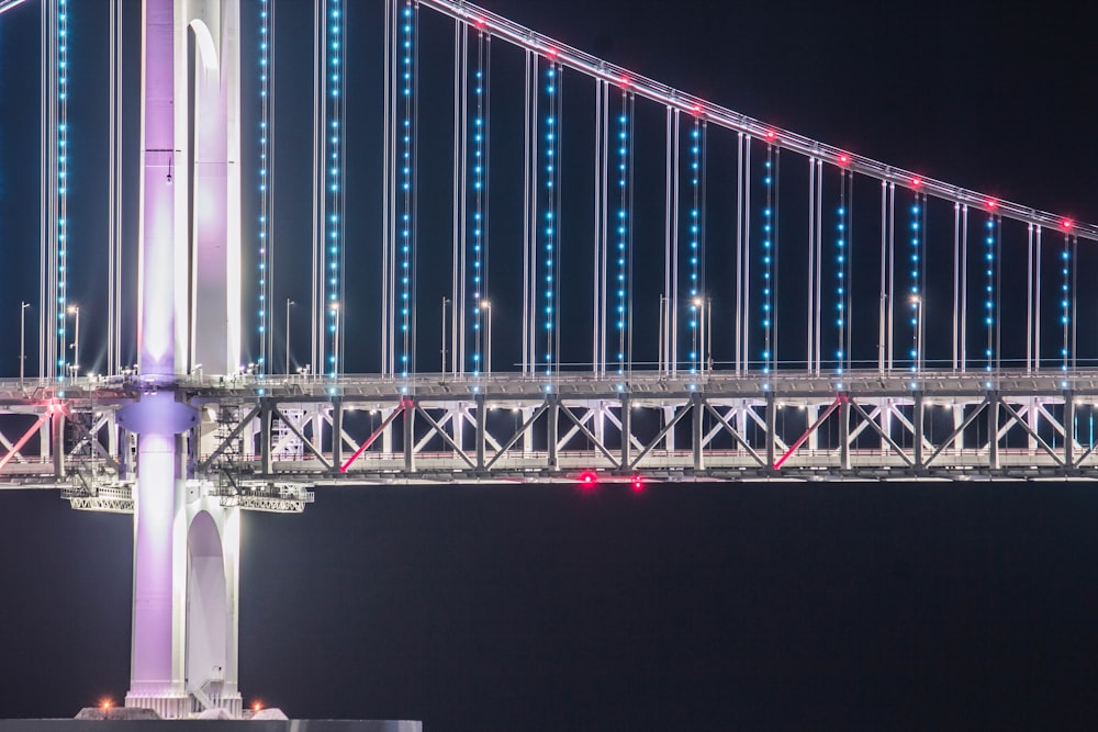 a large bridge lit up with blue and red lights