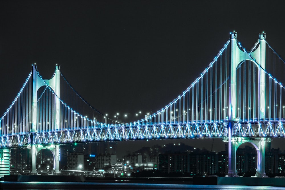 a large bridge lit up at night over a body of water