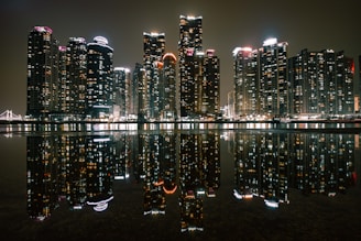 a city at night reflected in a body of water