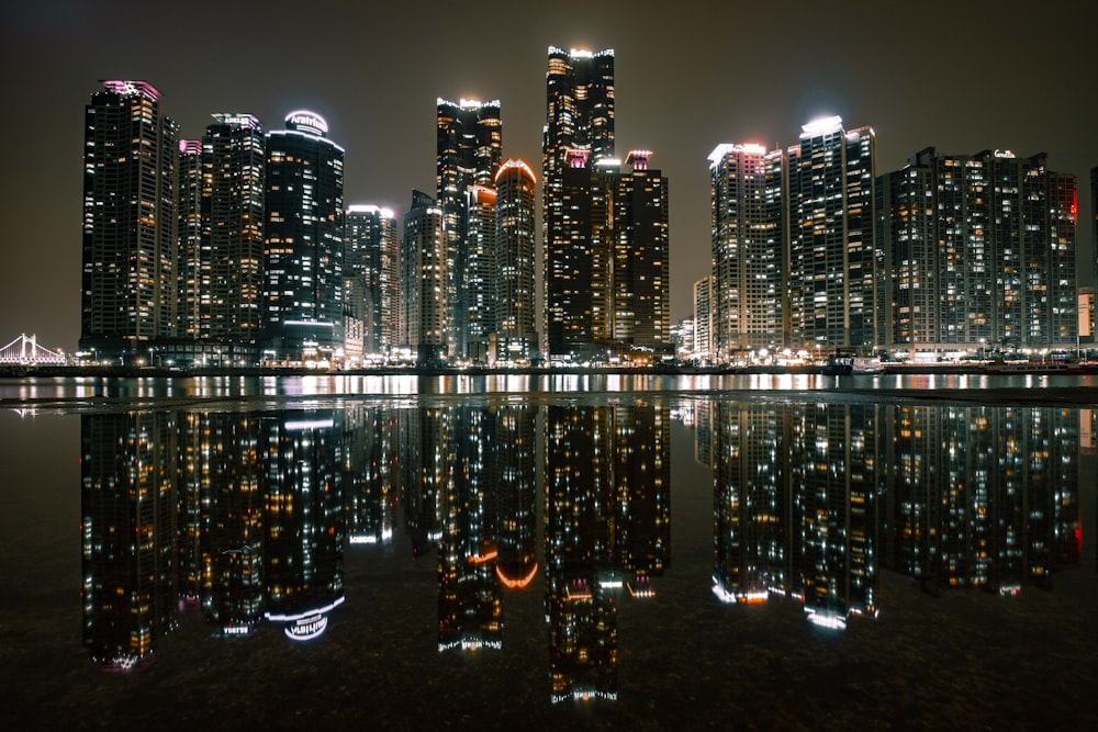 a city at night reflected in a body of water