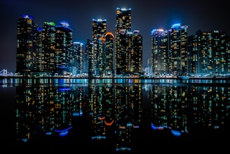 a city at night reflected in the water