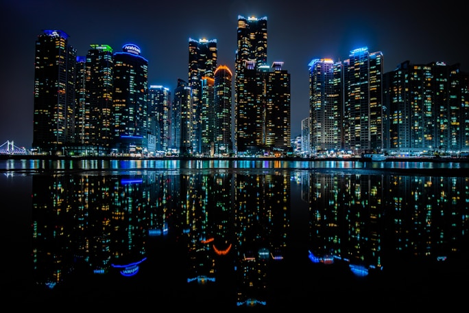 a city at night reflected in the water