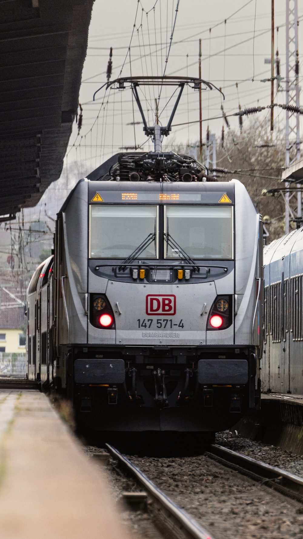 a silver train pulling into a train station