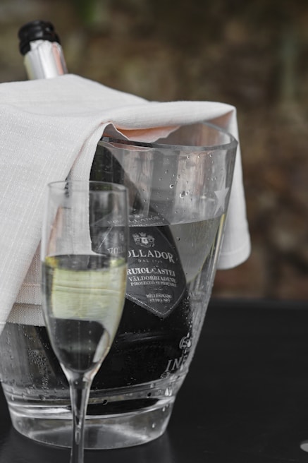 Close-up of sparkling wine bottles chilling in an ice bucket with condensation