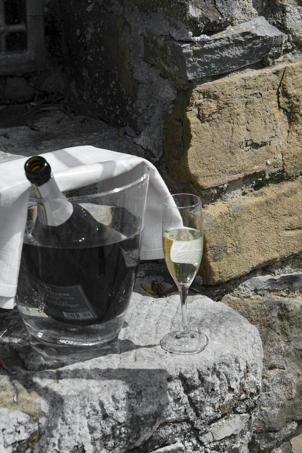a bottle of wine and a glass on a rock