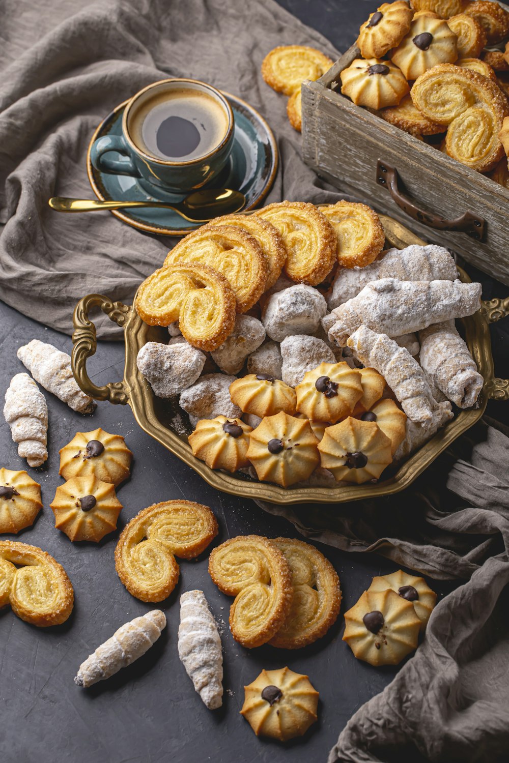 a table topped with lots of pastries next to a cup of coffee