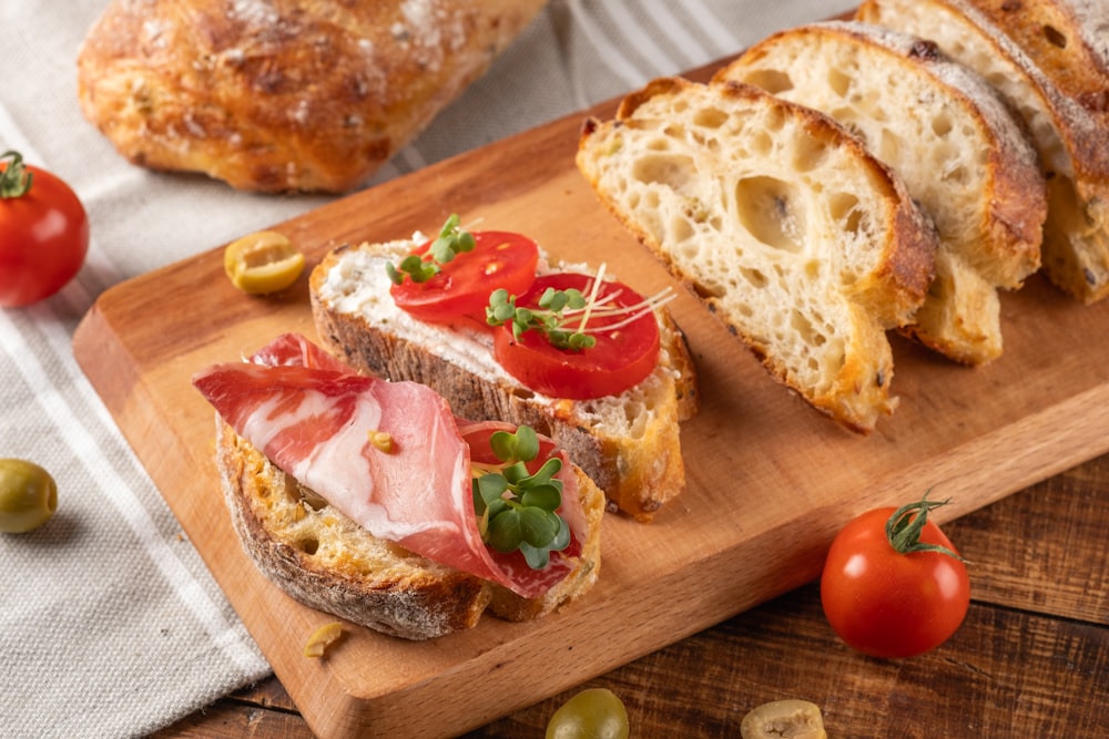 a wooden cutting board topped with slices of bread