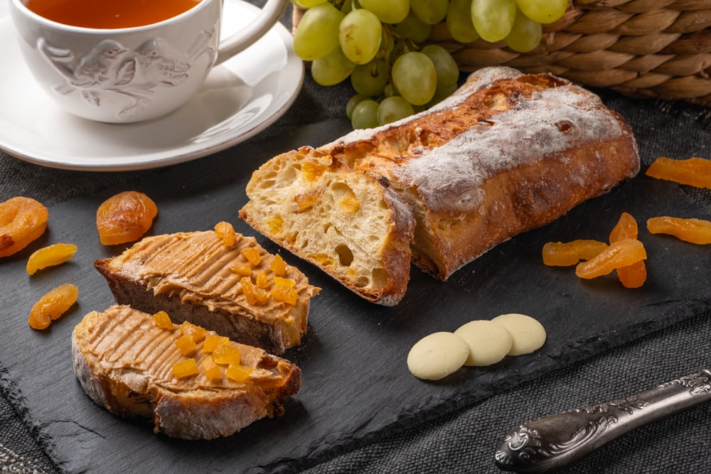 a loaf of bread sitting on top of a table next to a cup of tea