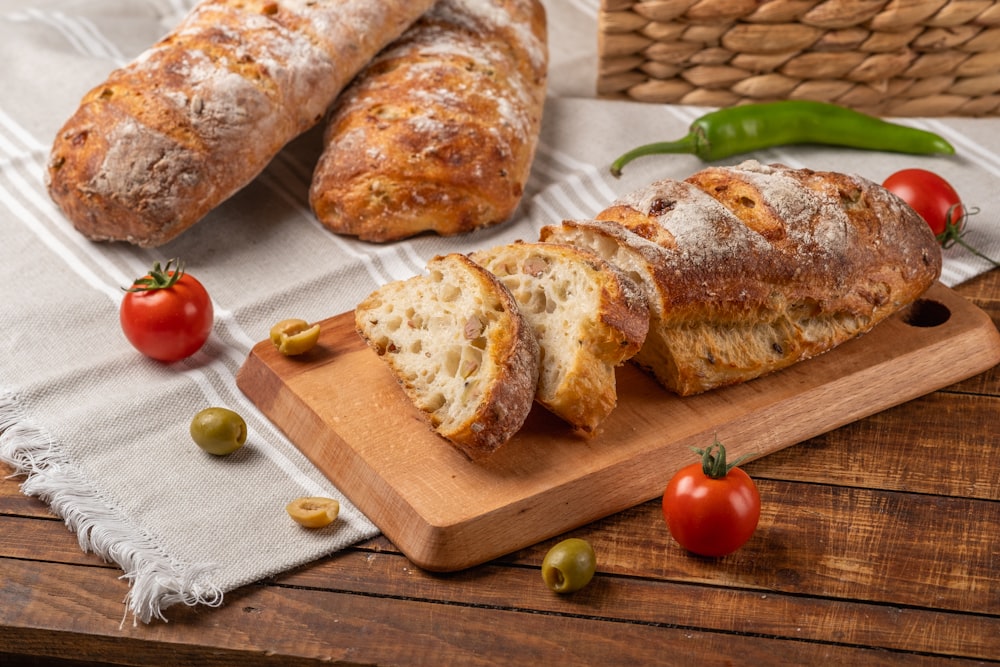 a loaf of bread sitting on top of a wooden cutting board