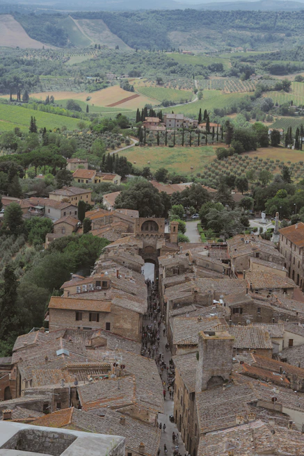 A charming cobblestone street in a Tuscan village bustling with locals and colorful market stalls.