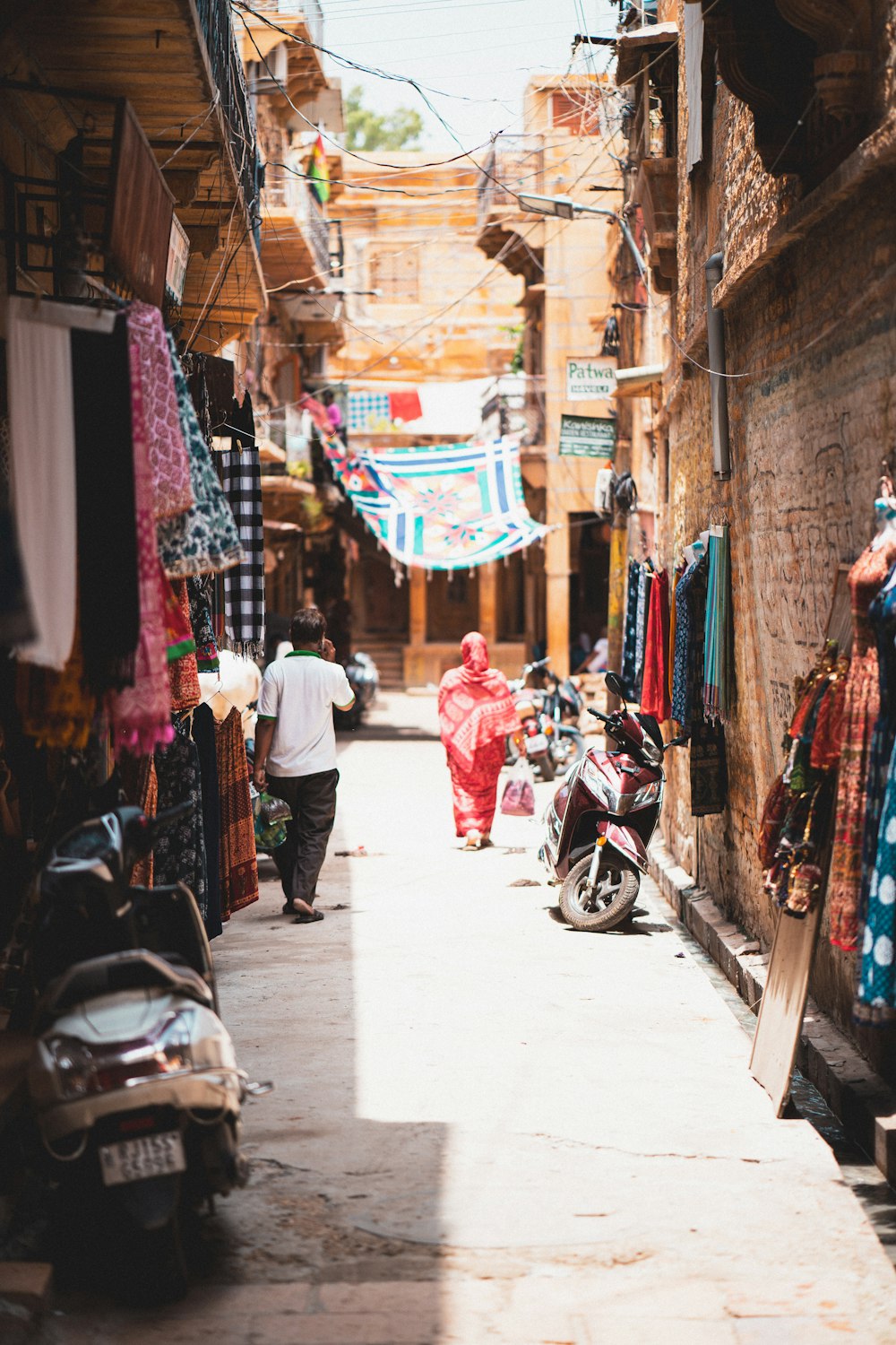 a man walking down a street next to a motorcycle