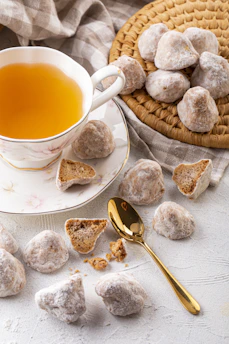An assortment of biscuits displayed alongside a cup of tea on a sunny afternoon.