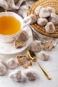 a cup of tea next to a plate of cookies