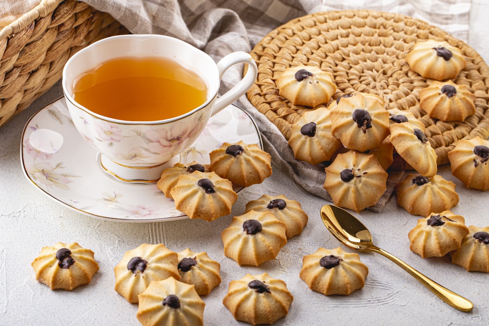 a cup of tea next to a plate of cookies