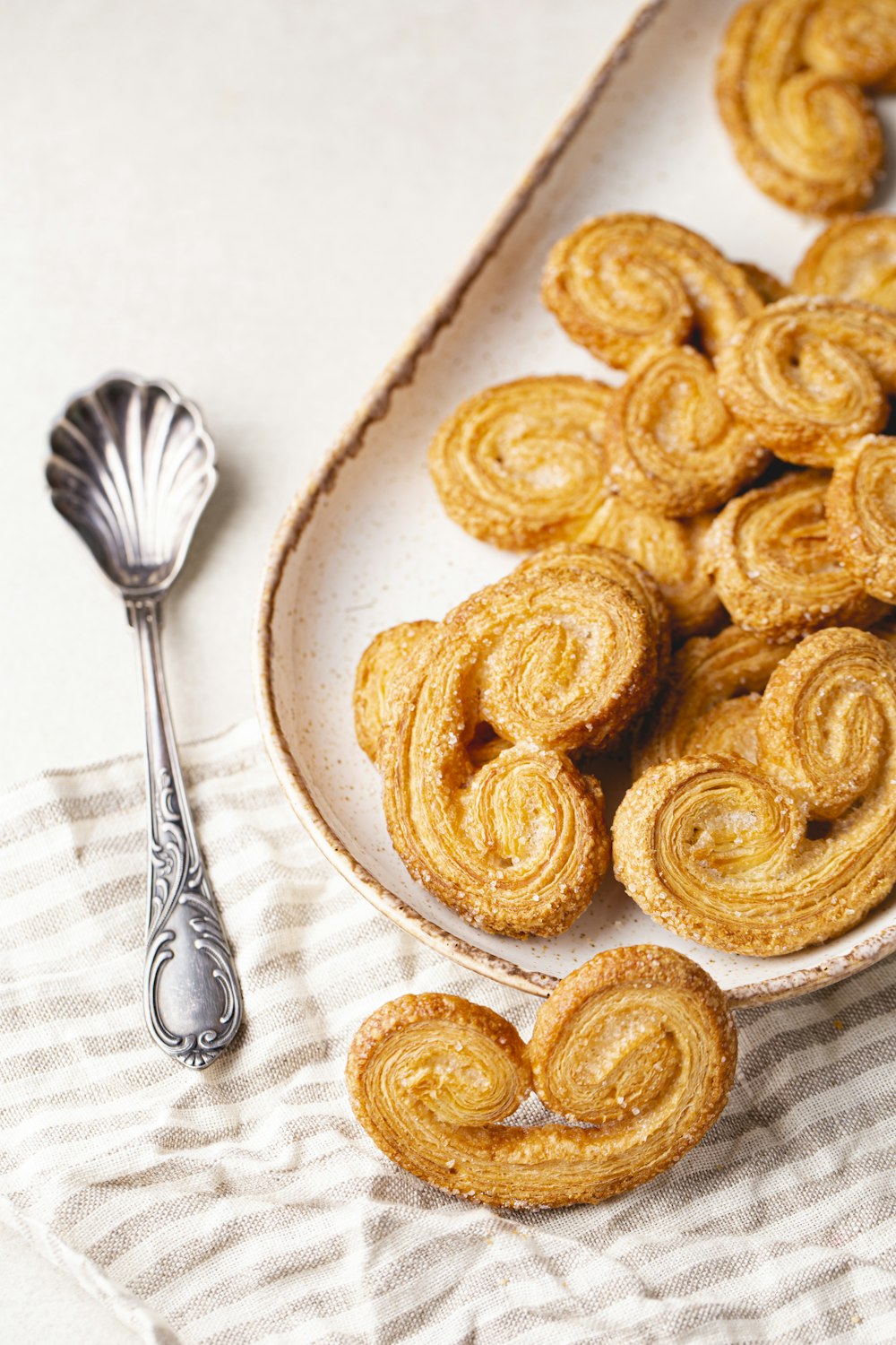 a white plate topped with pastries next to a spoon