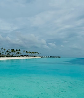 A serene beach scene in Thailand with turquoise waters, palm trees, and a luxurious overwater bungalow.