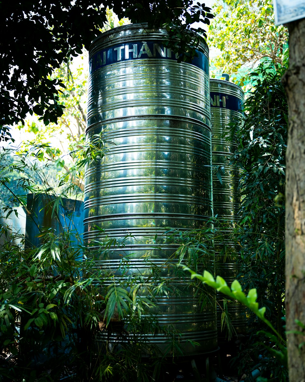 a couple of large metal containers sitting in the middle of a forest