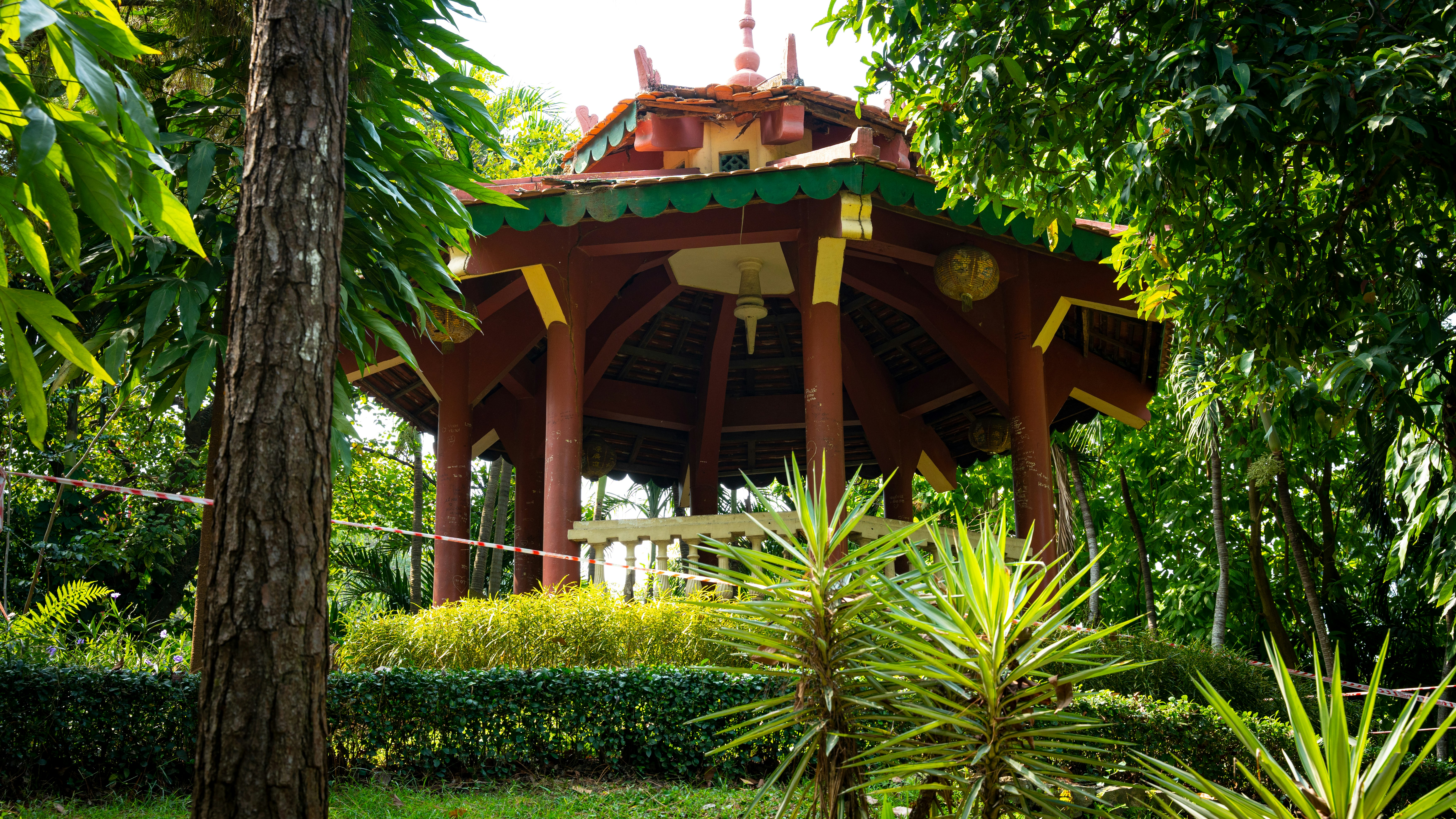a wooden gazebo surrounded by lush green trees