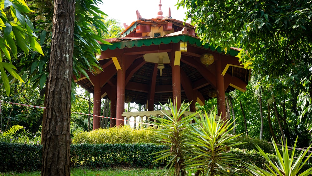 a wooden gazebo surrounded by lush green trees