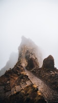 A winding mountain trail disappearing into mist, evoking a sense of mystery and discovery.