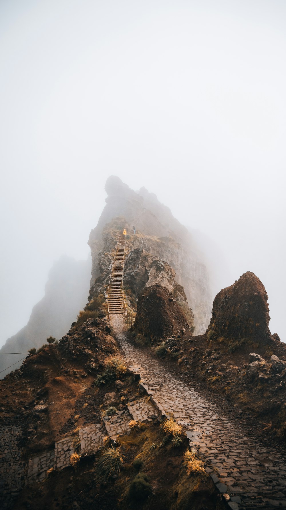 a foggy mountain with stairs leading up to the top