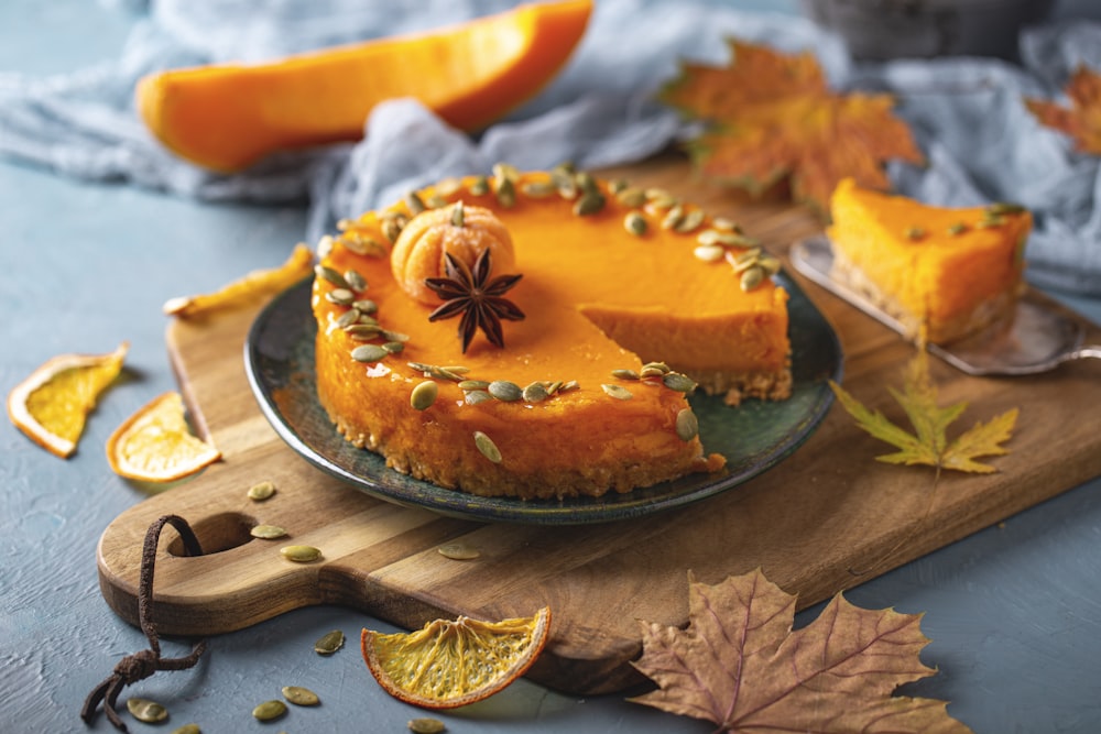 a pumpkin cheesecake on a wooden cutting board