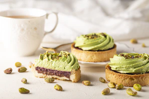 Individual pistachio tiramisu slice artfully plated with a dusting of cocoa powder and gold accents.