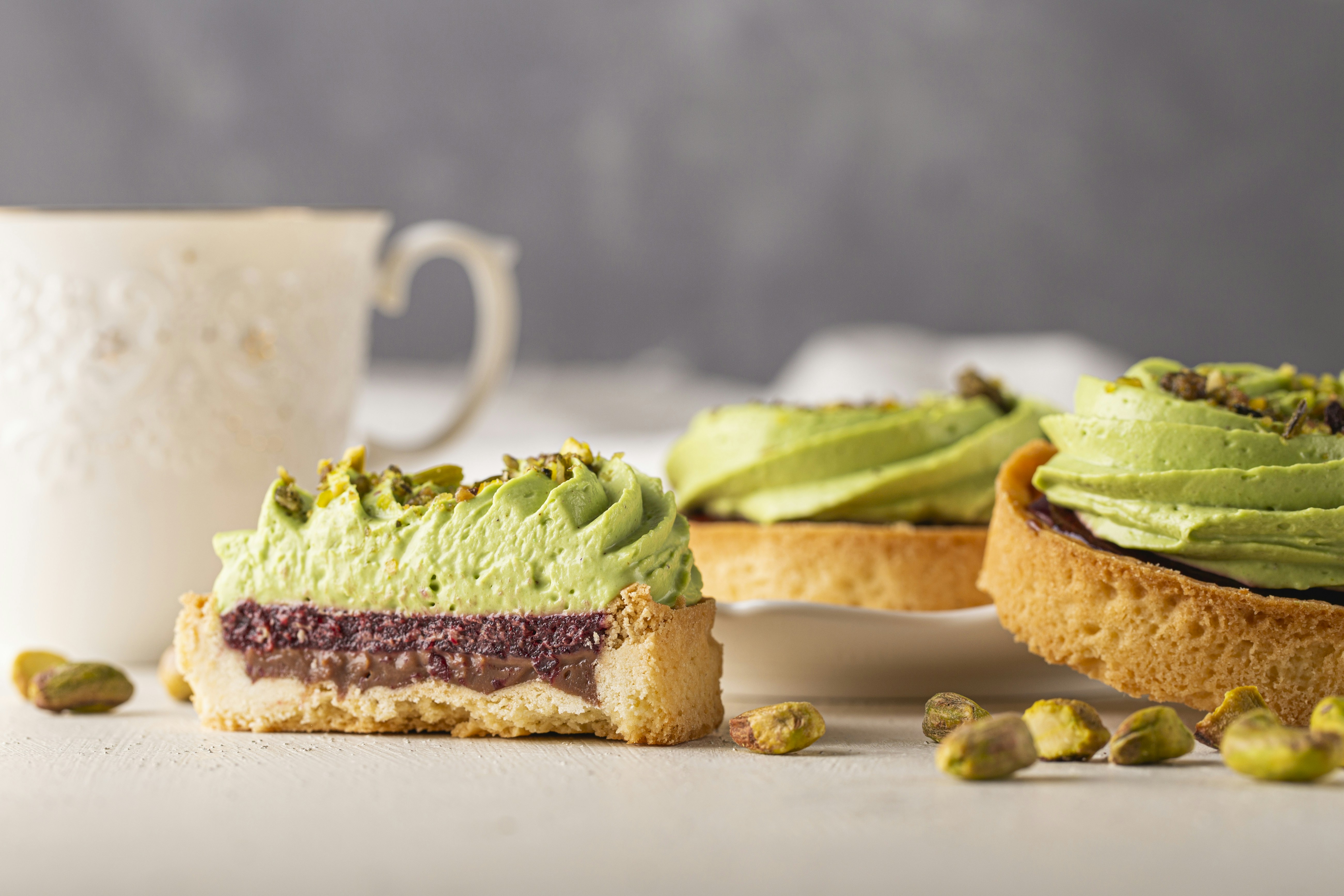 a close up of a pastry with a cup of coffee in the background