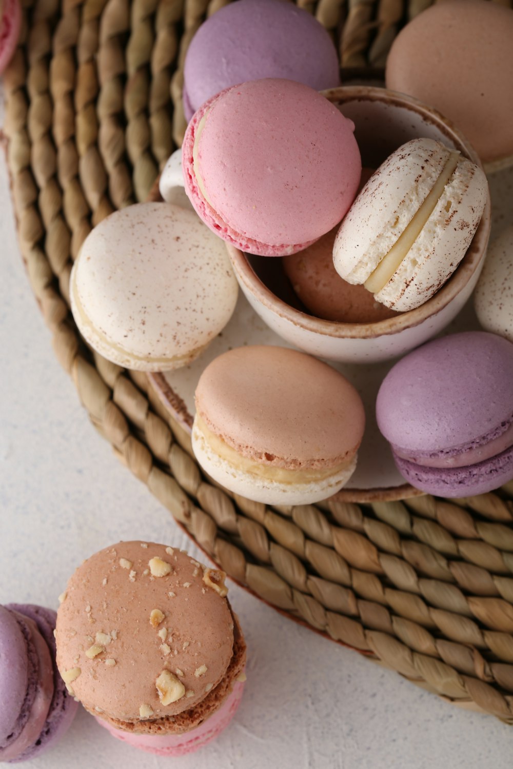 a wicker basket filled with different colored macaroons